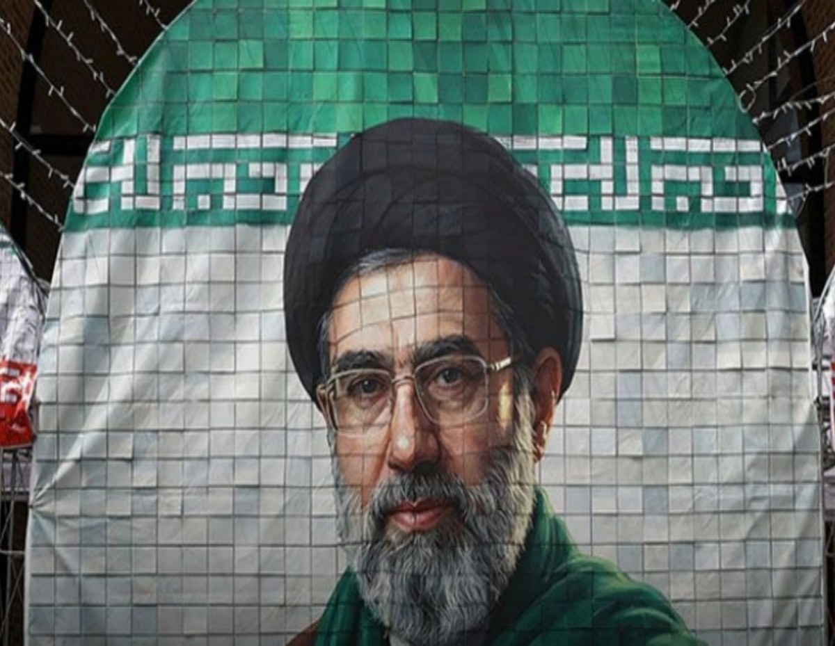 Large banner featuring a bearded man in a black turban and glasses, against a green-and-white background.