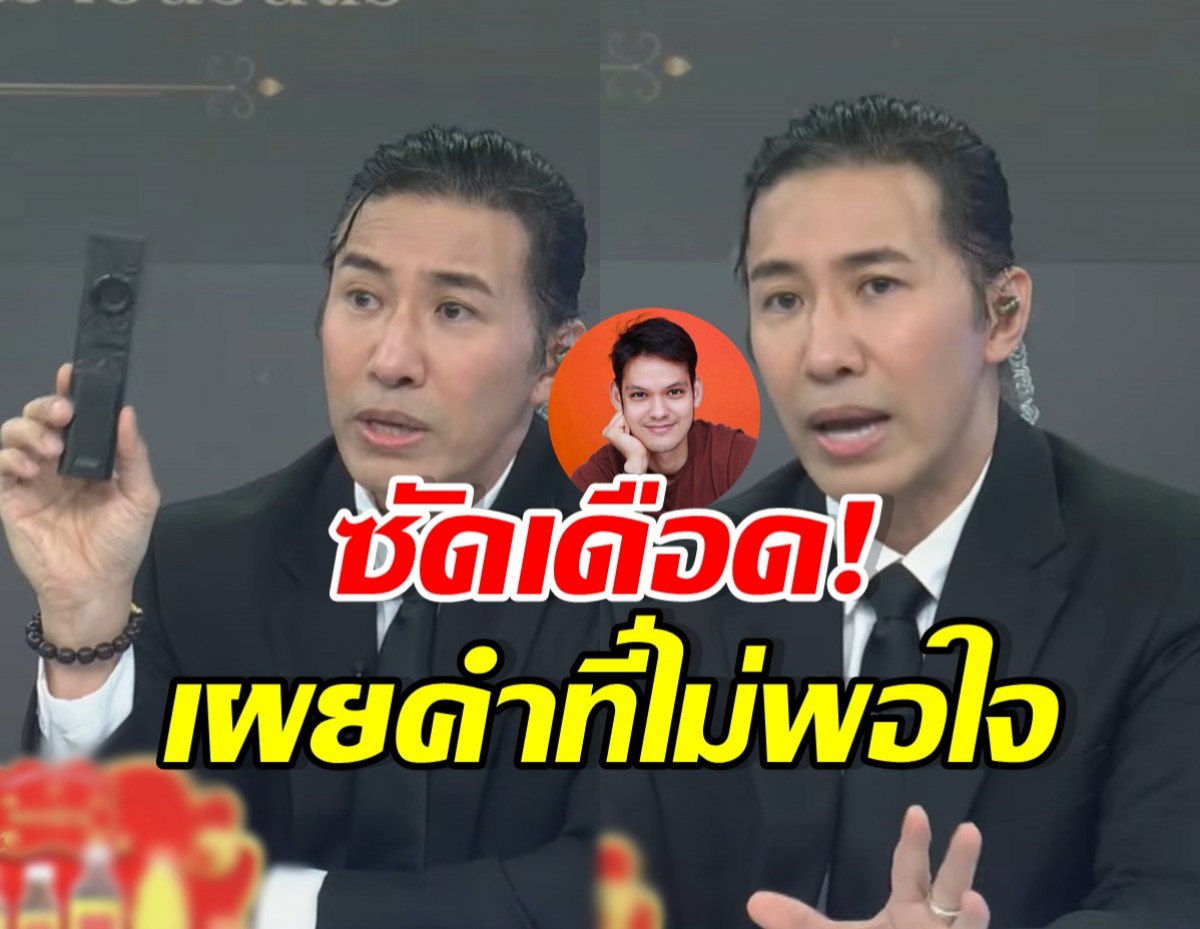 Two men in black suits speak on a talk-show set, holding a remote, with bold Thai captions over a circular profile image in the center.