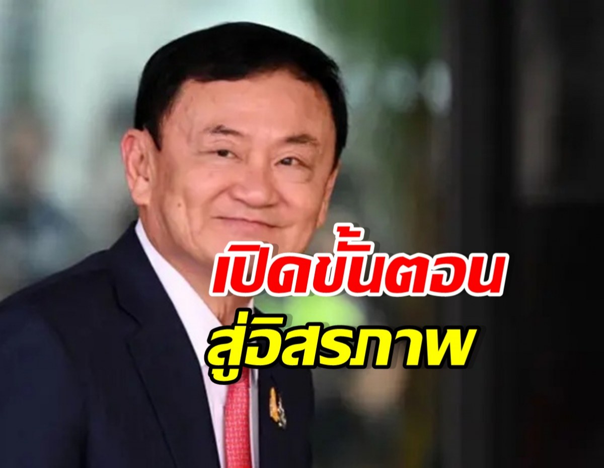 Smiling man in a dark suit with a pink tie, large bold red Thai text overlaying the lower face, and a yellow line of Thai text beneath.