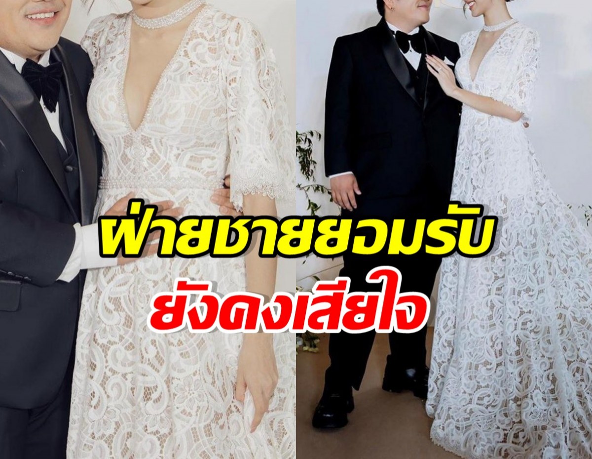 คู่บ่าวสาวในชุดแต่งงานสีขาวลายลูกไม้ ยืนคู่กันในงานแต่งงาน ฝ่ายชายสวมทักซิโด้สีดำ